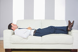 Calm handsome businessman lying on couch