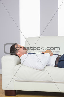 Peaceful handsome businessman lying on couch