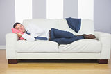 Tired attractive businessman lying on couch