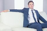 Content handsome businessman relaxing on couch