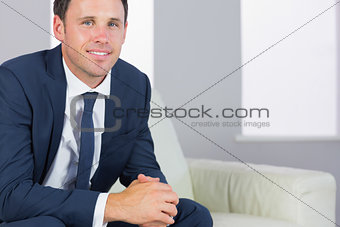 Happy handsome businessman relaxing on couch