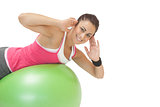 Cheerful sporty brunette doing exercise on exercise ball