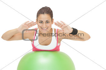 Happy sporty brunette doing exercise on exercise ball