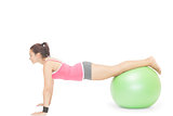 Content sporty brunette doing exercise with exercise ball