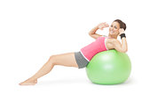 Smiling sporty brunette doing sit ups on exercise ball