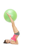 Smiling sporty brunette holding exercise ball between legs