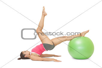 Attractive sporty brunette exercising with exercise ball