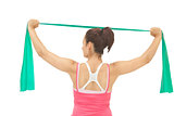 Rear view of sporty brunette stretching with resistance band