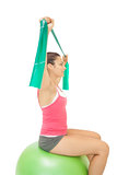 Smiling sporty brunette stretching with resistance band