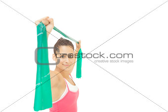 Happy sporty brunette stretching with resistance band