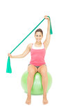 Cheery sporty brunette stretching with resistance band