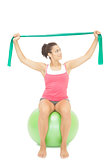 Attractive sporty brunette stretching with resistance band