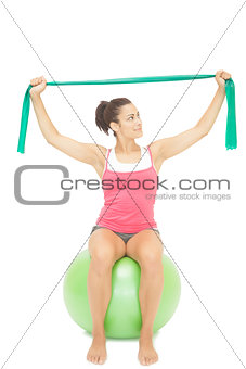 Attractive sporty brunette stretching with resistance band