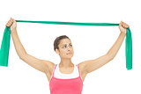 Calm sporty brunette stretching with resistance band