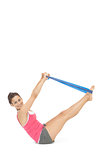 Cheerful sporty brunette exercising with resistance band