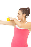 Content sporty brunette touching arm with yellow massage ball