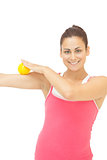 Smiling sporty brunette touching arm with yellow massage ball
