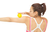 Rear view of sporty brunette touching arm with yellow massage ball