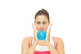Content sporty brunette holding blue massage ball between hands