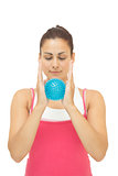 Smiling sporty brunette holding blue massage ball between hands