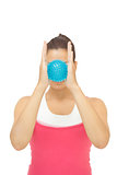 Sporty brunette holding blue massage ball between hands