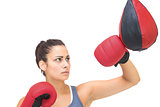 Serious sporty brunette training with punching bag