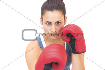 Attractive sporty brunette wearing red boxing gloves