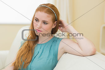 Thoughtful redhead sitting on the couch