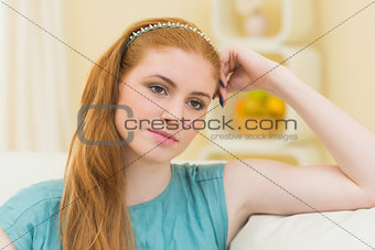 Thinking redhead sitting on the couch