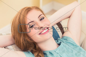 Relaxed redhead lying on the couch looking at camera