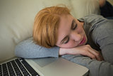 Redhead sleeping on the sofa with her laptop