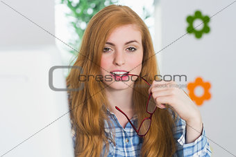 Beautiful redhead sitting at her desk smiling at camera