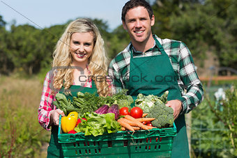 Proud young couple showing vegetables