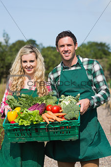 Proud couple showing vegetables in a basket