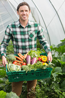 Young man presenting proudly some vegetables