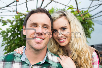 Sweet young couple posing in their green house