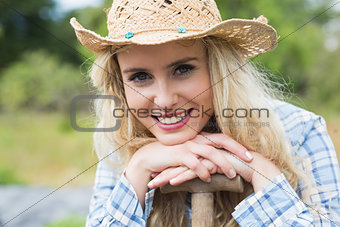 Young woman leaning on a shovel
