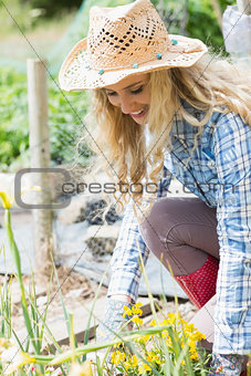 Smiling blonde woman working in the garden