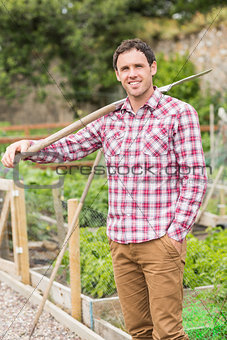 Young brunette man posing with a shovel