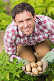 Young man holding some potatoes