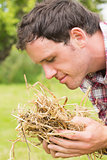 Young man smelling yellow straw