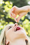 Blonde woman eating a cherry
