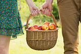 Basket of apples being carried by a young couple