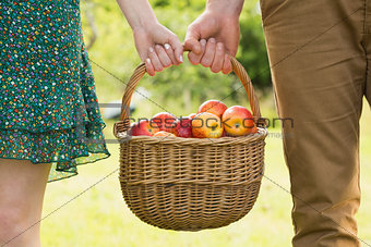 Basket of apples being carried by a young couple