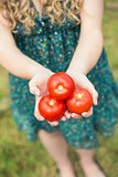 Blonde woman holding some tomatoes