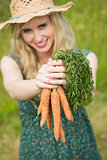 Smiling woman presenting some carrots