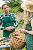 Young farmer selling organic vegetables to pretty blonde