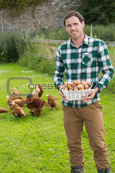 Happy man showing a basket filled with eggs