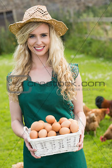 Happy young woman holding a basket with eggs