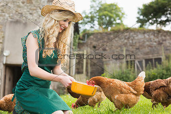 Young blonde feeding her chickens
